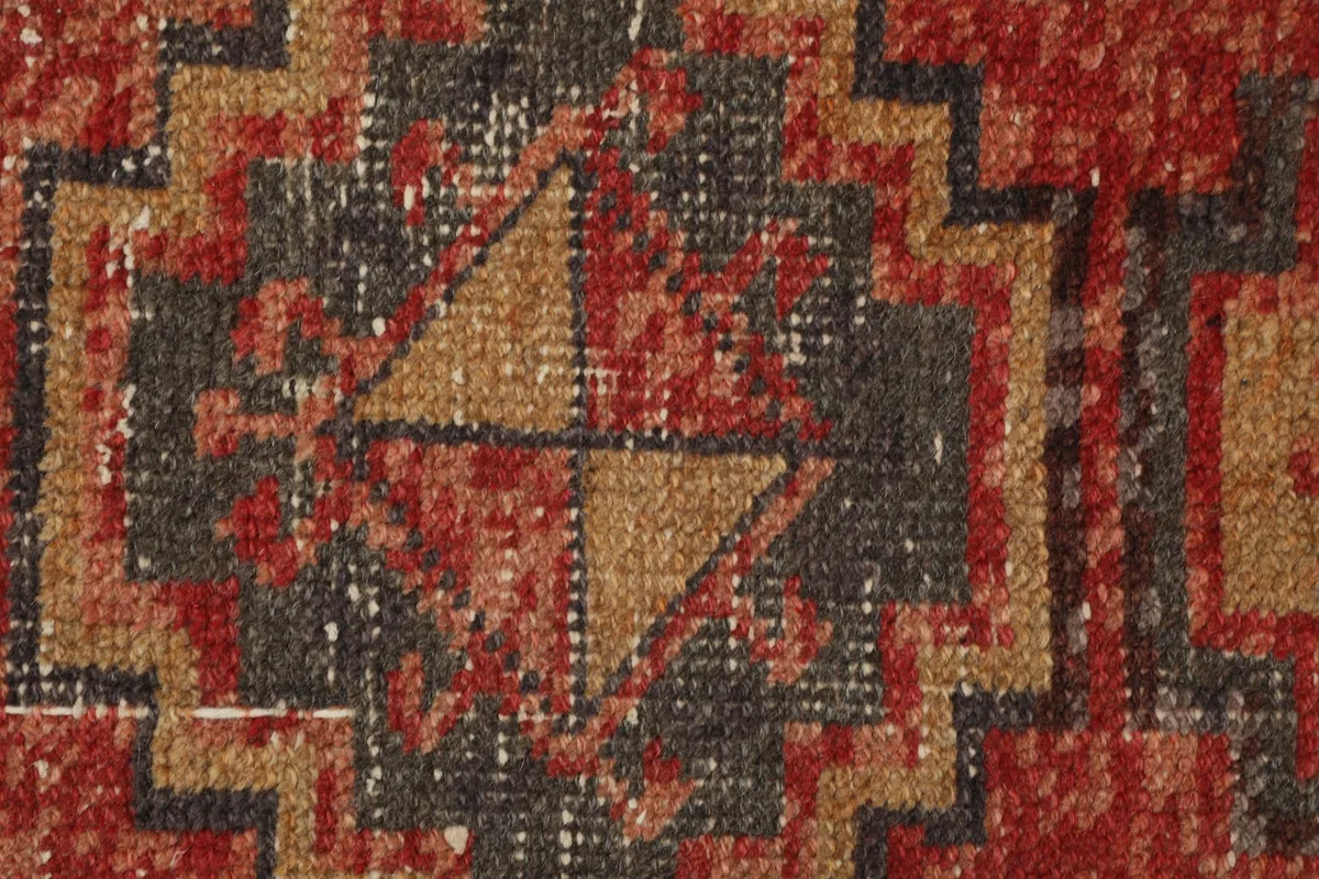 Extreme close-up of the hand-knotted wool pile and the intricate geometric design.