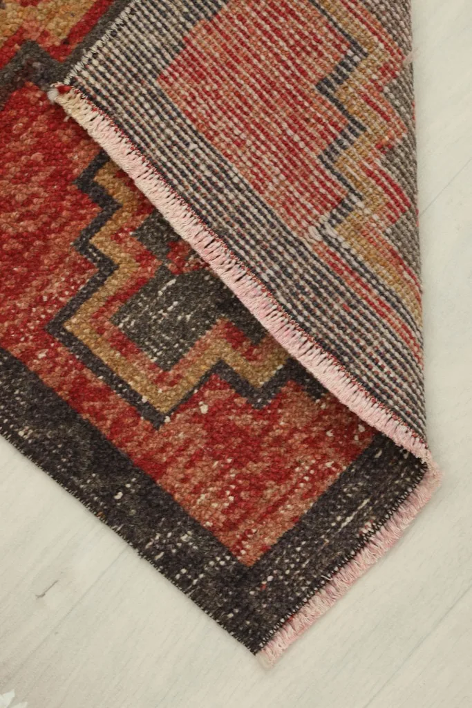 View of the rug's reverse side, revealing the cotton foundation and hand-knotted construction.
