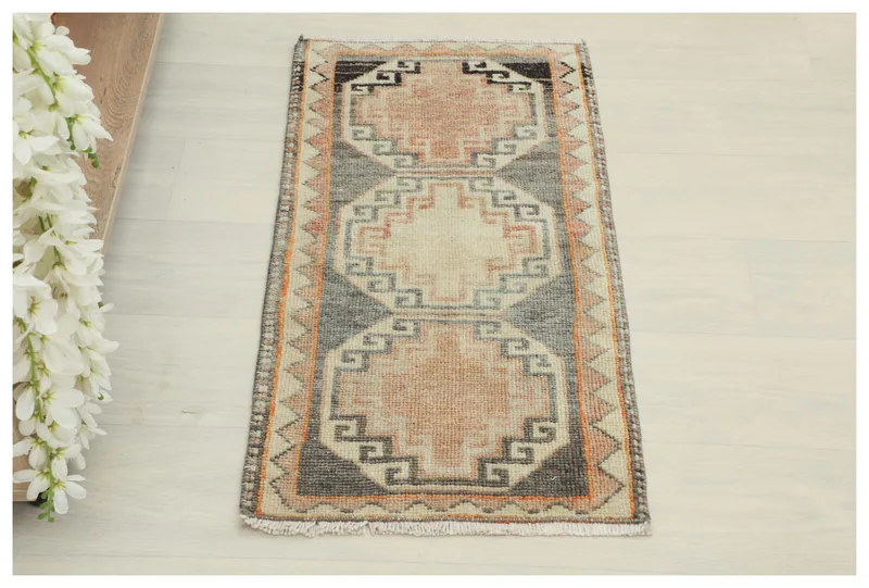 Full top view of the 1'5" x 2'9" vintage Anatolian rug with rose and charcoal geometric patterns