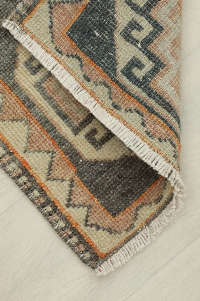 Rug corner folded back, showing the cotton foundation and the reverse side of the knots