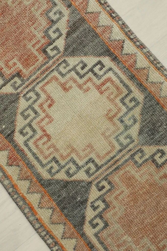 Overhead view showing the distressed texture and intricate geometric patterns of the rug