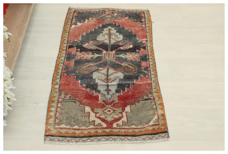 Full top view of the vintage charcoal and rust tribal Anatolian rug on a white background.