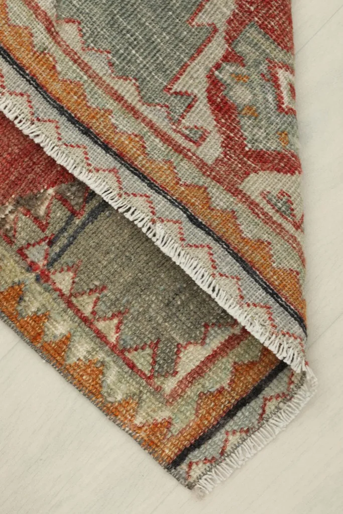 View of the rug folded over, showing the thickness of the wool pile and cotton foundation.