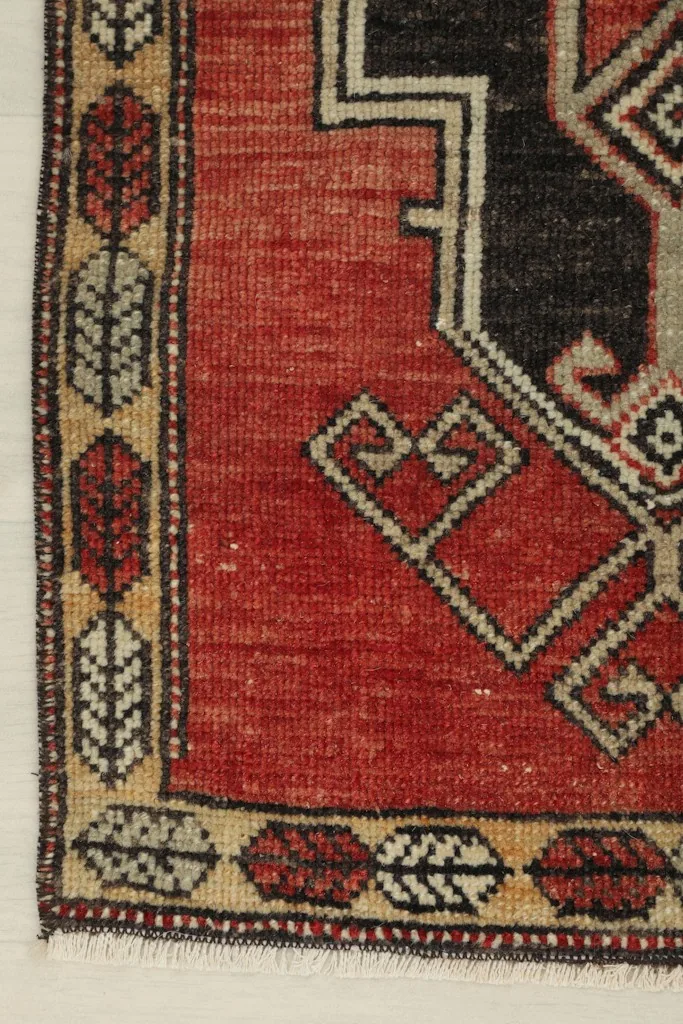 Close-up of the rug's right border, showcasing the tan and beige leaf-like patterns.