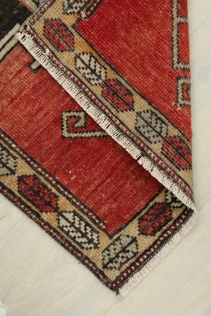 Close-up showing the low wool pile and texture of the hand-knotted vintage rug.