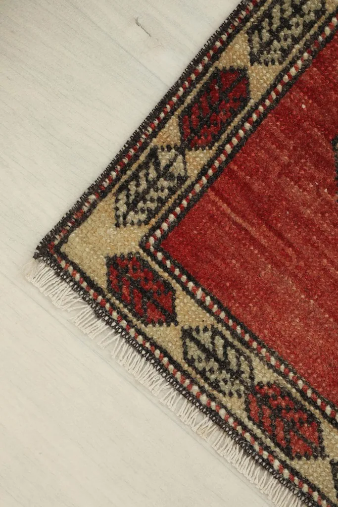 Angled shot of the rug's top right corner, showing the wool pile and border design.
