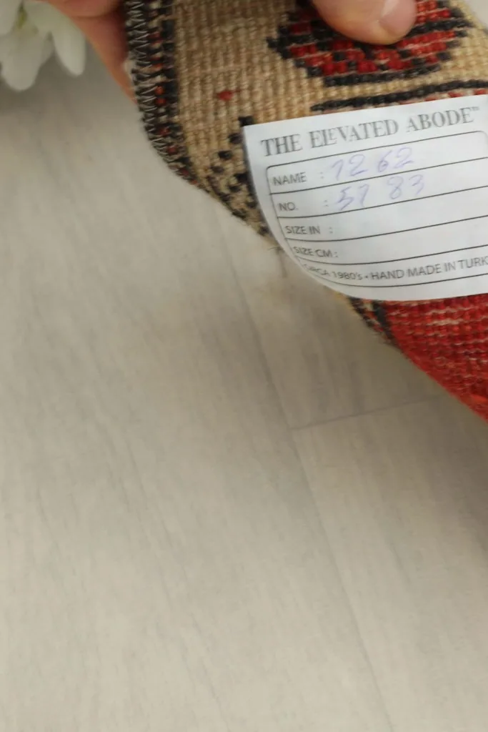 Close-up of the rug's back, showing the professional cleaning tag and cotton foundation.
