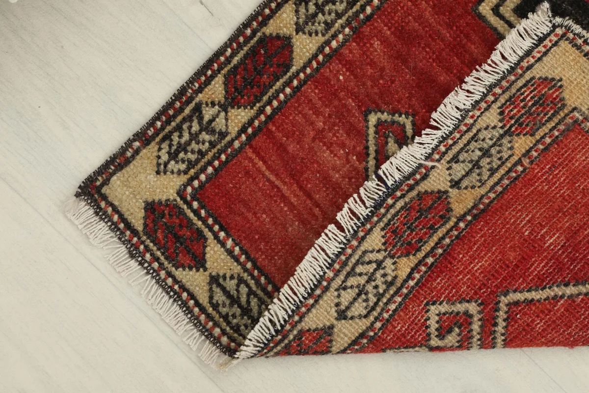 The rug partially folded, revealing the reverse side and the hand-knotted structure.