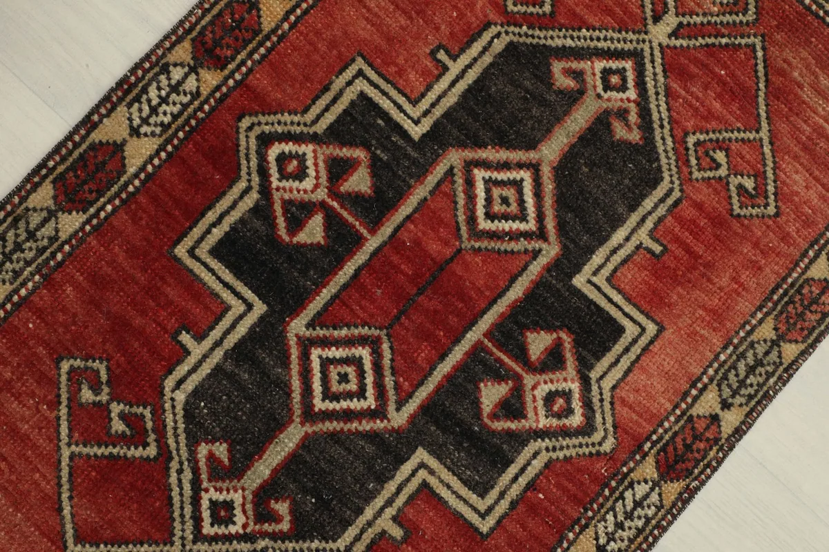 Overhead view focusing on the central black geometric design against the red field.
