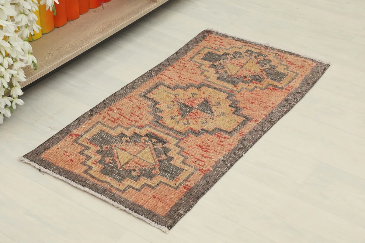 Angled view of the vintage Anatolian doormat, showing its full design and colors.