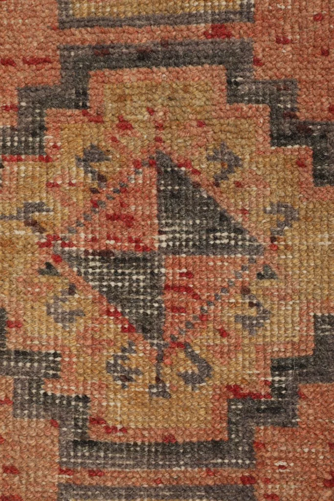 Detailed close-up of the hand-knotted wool pile and intricate tribal design elements.