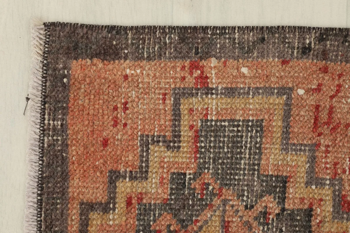 Corner detail of the rug, highlighting the charcoal border and fringe.
