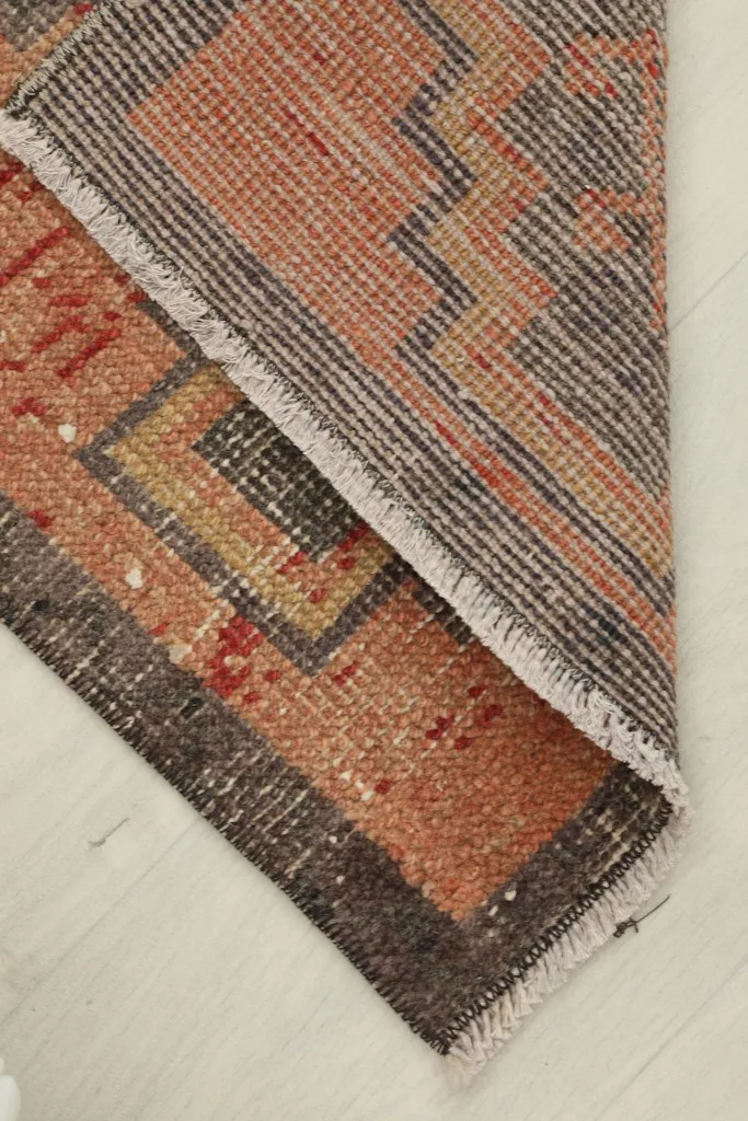 Partial fold of the rug, revealing the cotton foundation and reverse side.