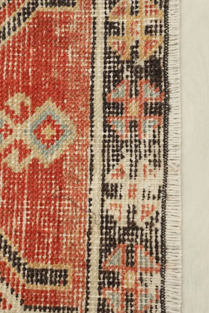 Close-up detail of the doormat's border and fringe, showing weave and colors