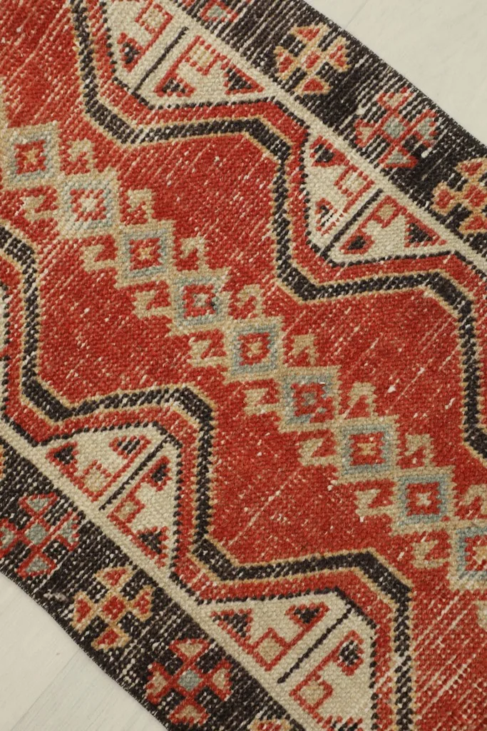 Detailed view of the central red field and geometric patterns in beige and gray