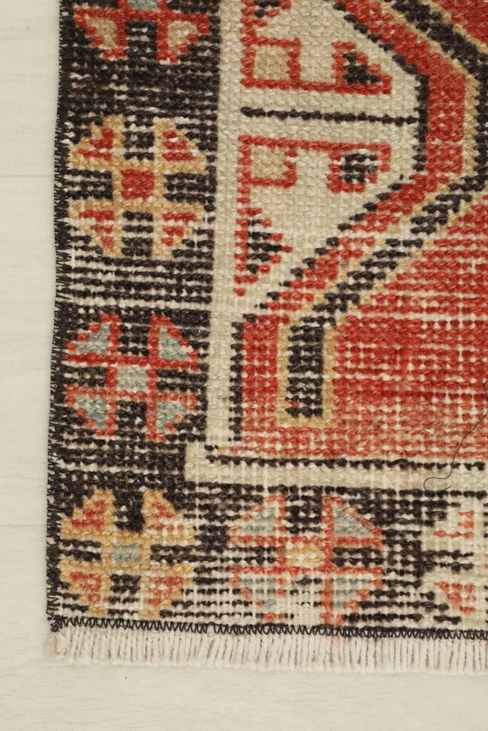 Corner detail of the doormat, highlighting the black border and geometric motifs
