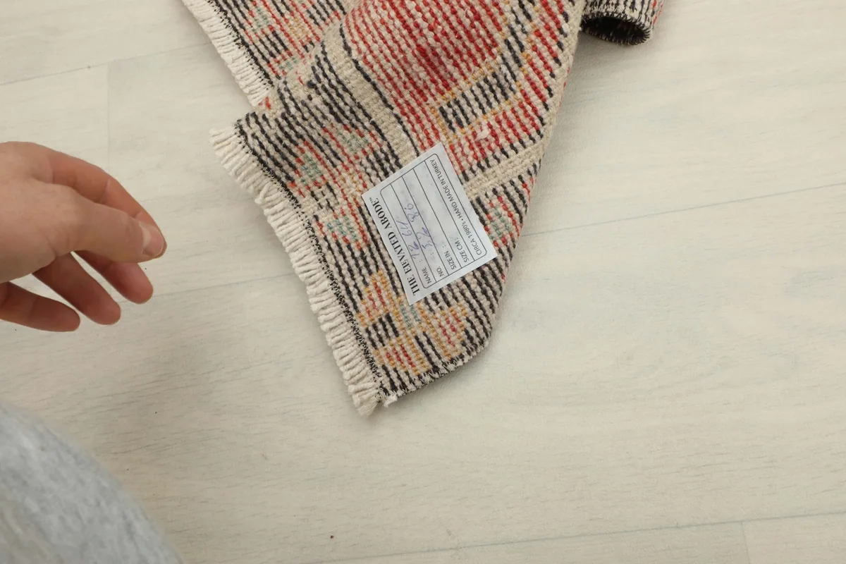 Close-up of the rug's reverse side, showing the hand-knotted cotton foundation and label