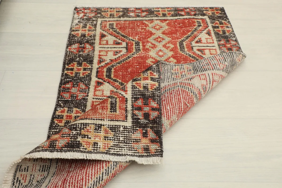 Overhead view of the doormat with one corner folded back, showing the back of the rug