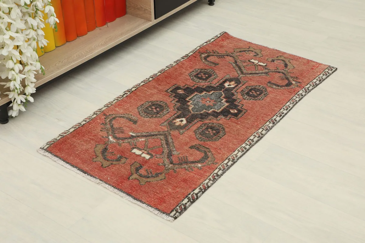 Angled view of the rust doormat, showing its full length and geometric pattern.