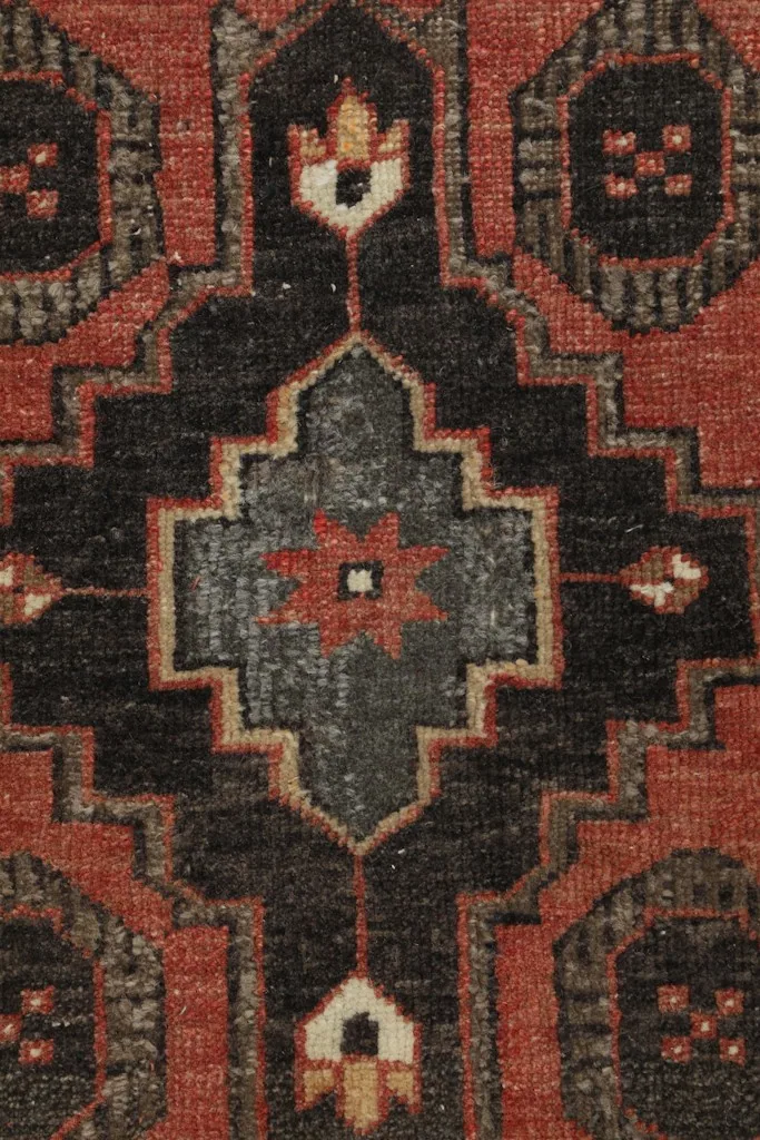 Detailed close-up of the central geometric medallion with black, gray, and rust colors.