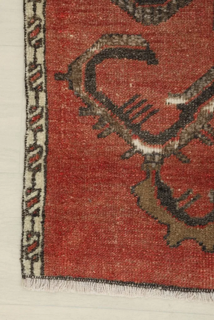 Close-up of the side border and corner of the rust doormat, showing edge details.