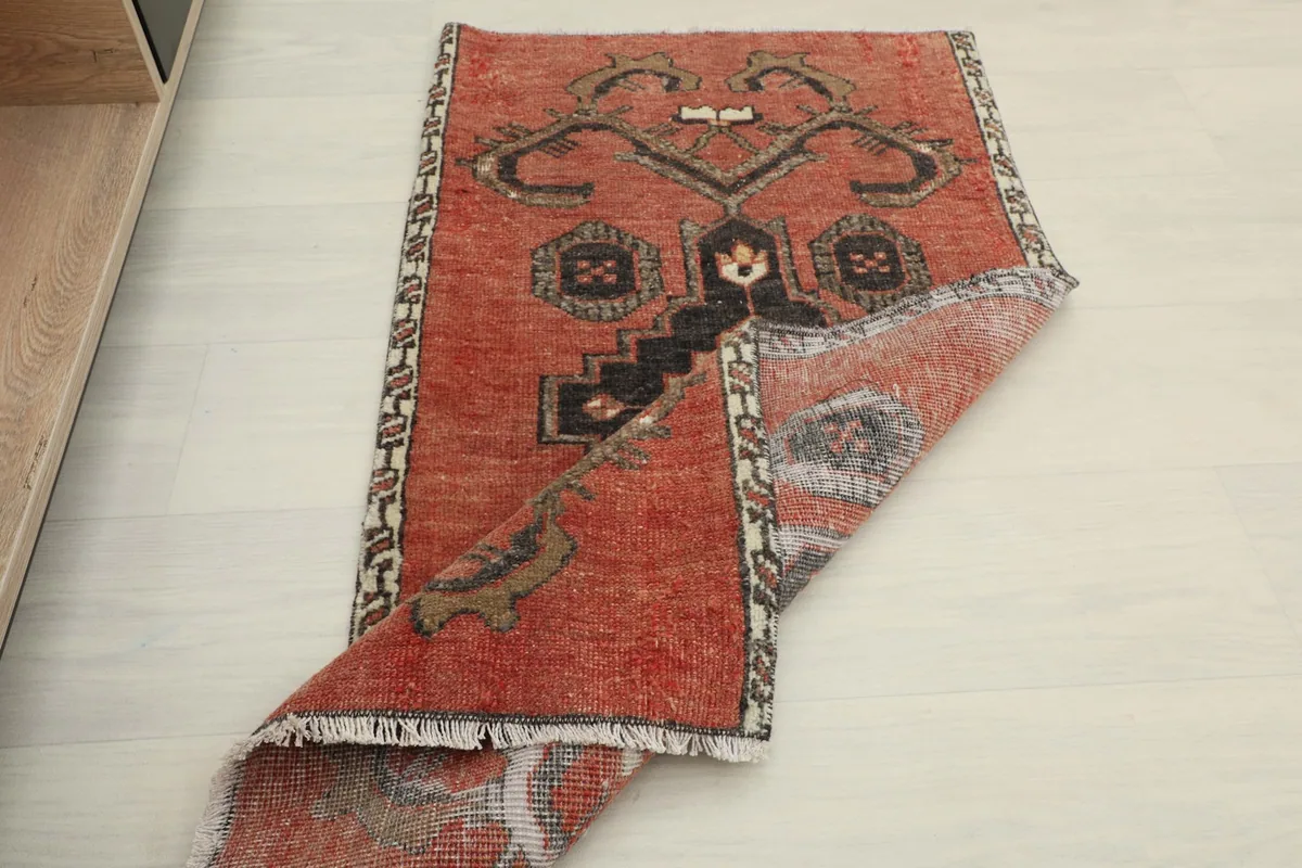 The rust doormat partially folded, revealing the reverse side and construction.