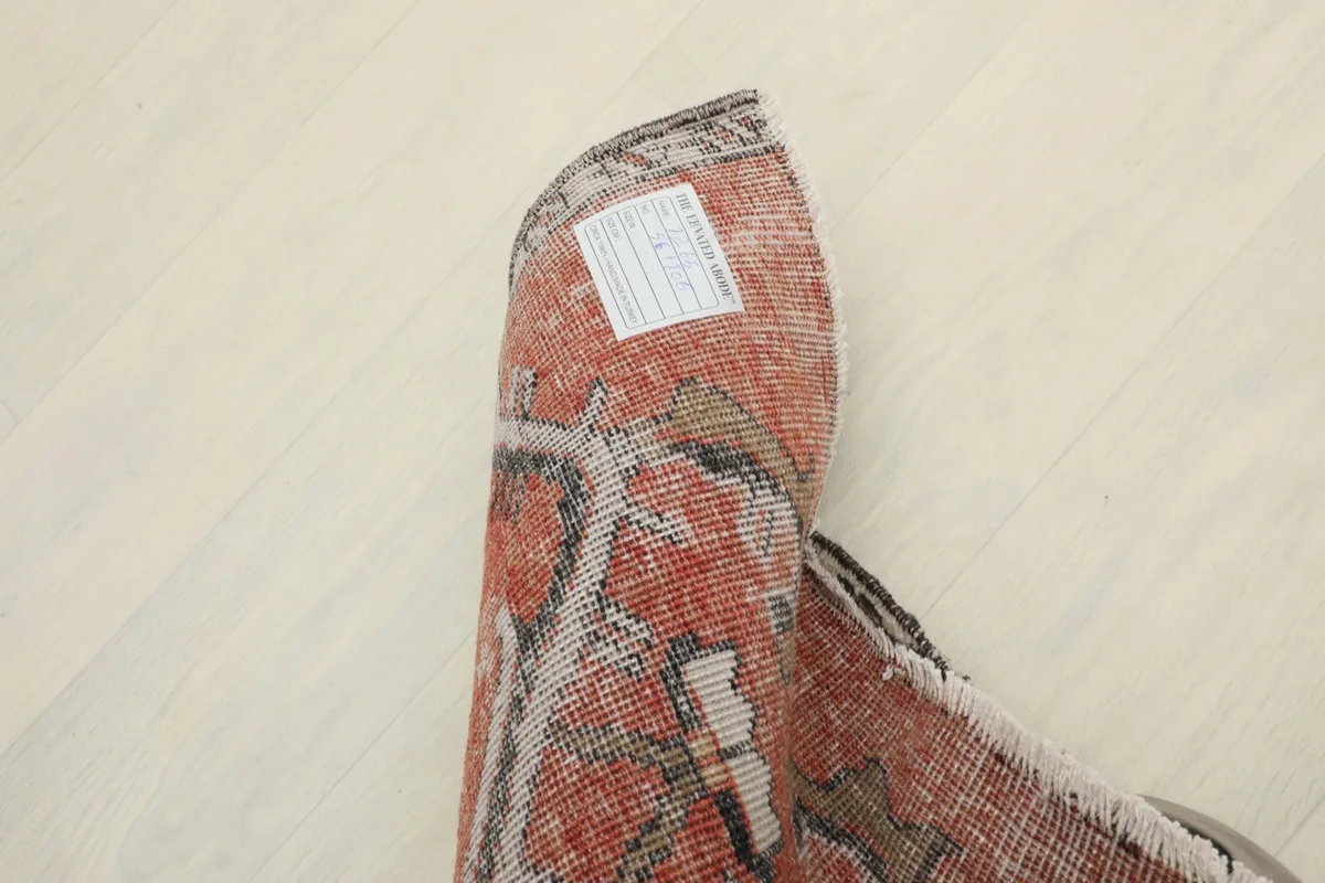The rug rolled up, showing its flexibility and the label on the reverse side.
