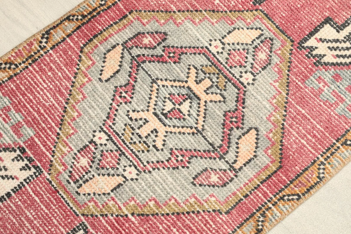 Close-up detail of the central gray medallion with intricate geometric shapes and rose accents