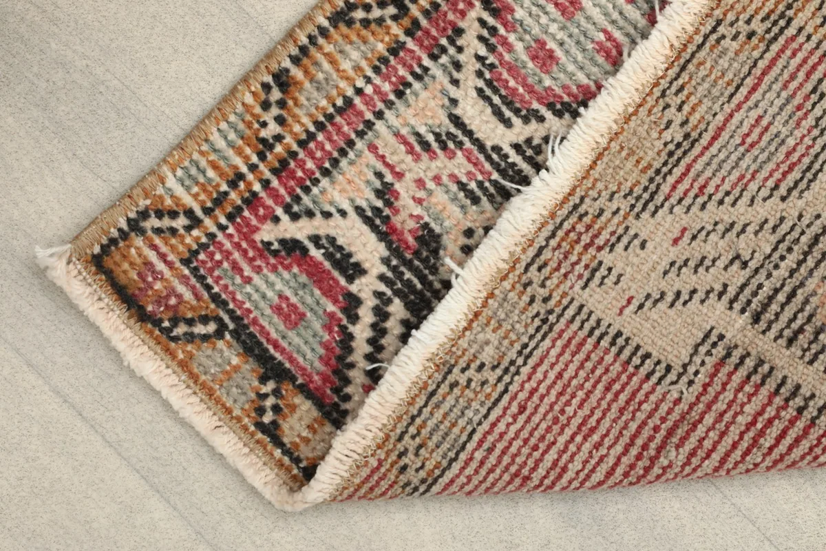 View of the back of the hand-knotted rug, revealing the cotton foundation and tight weave