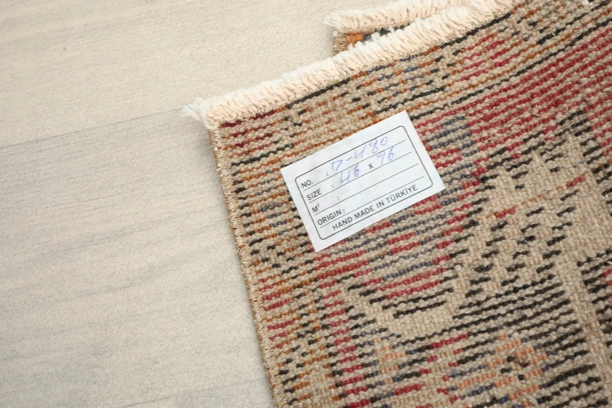 Back of the rug showing the hand-knotted construction and product label for origin and size