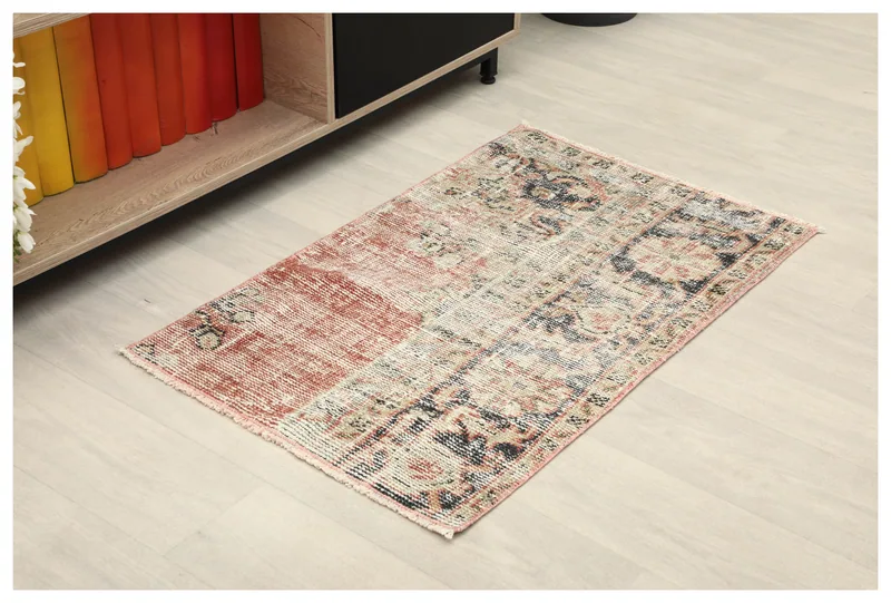 Full top view of the rust patchwork vintage Anatolian doormat on a light floor.