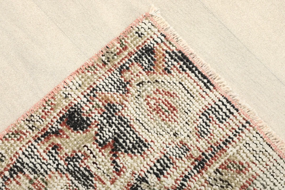 Close-up of one corner of the rug, showing the hand-knotted wool pile and fringe.
