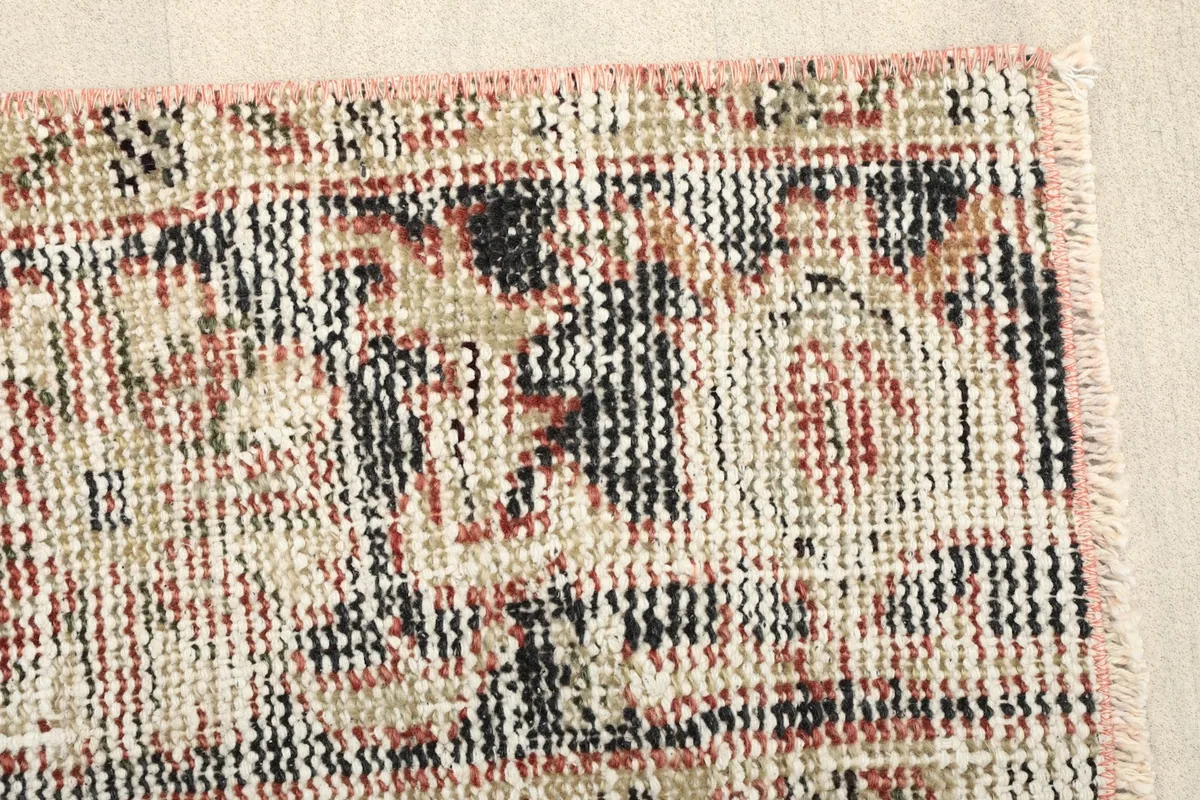 Detailed view of the distressed geometric patterns and color variations in the rug.