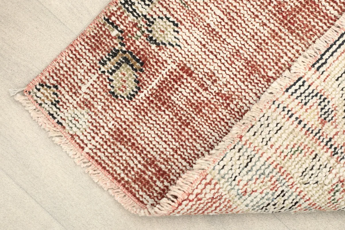 View of the back of the rug, showing the cotton foundation and hand-knotted construction.