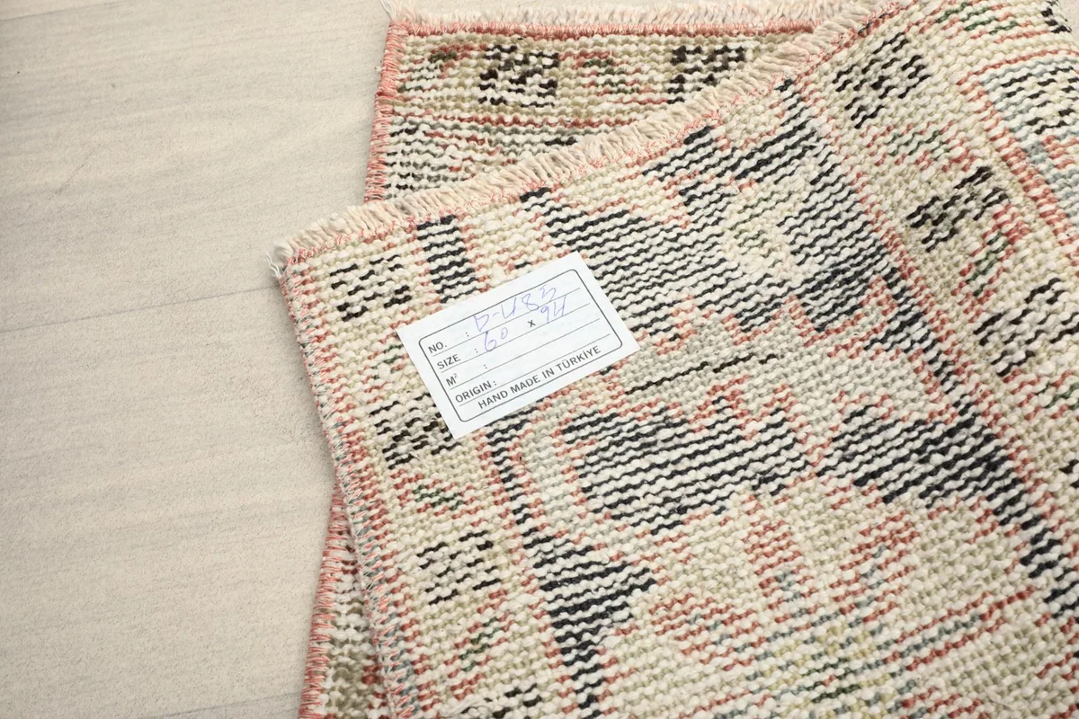 Close-up of the back of the rug with a label, indicating its origin and materials.