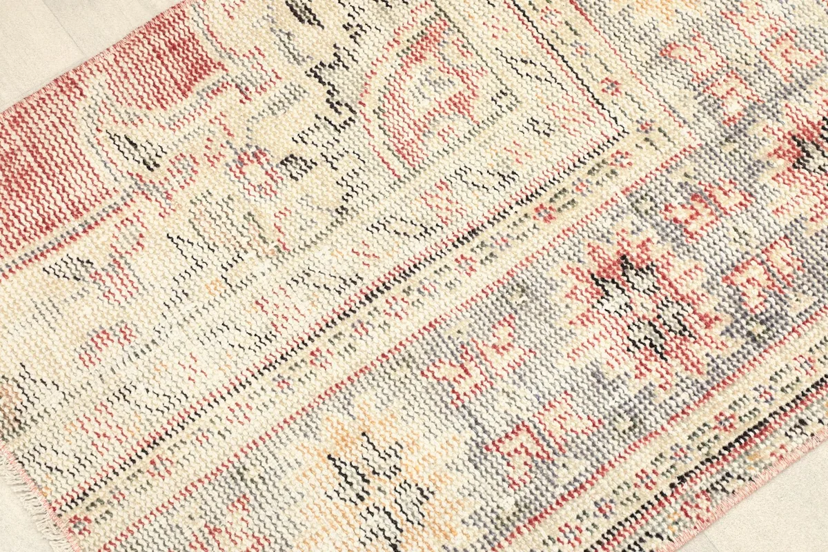 Angled view highlighting the low pile and textured surface of the vintage area rug.