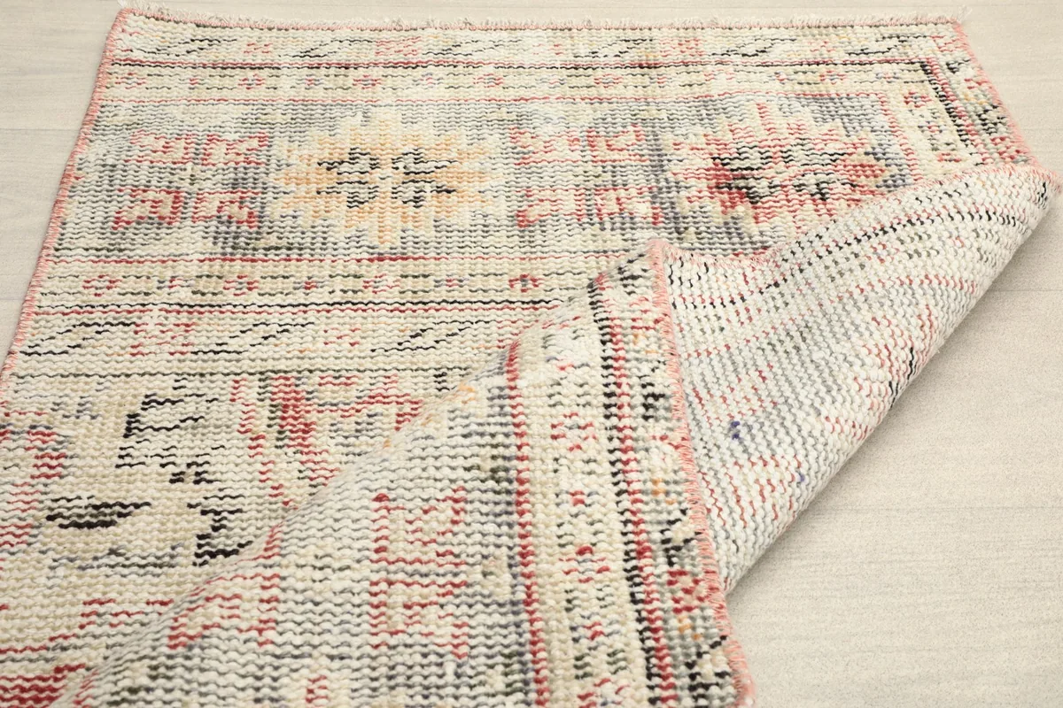 View of the rug's backside, showing the tight hand-knotted construction and foundation.