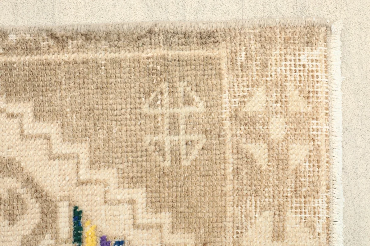 Close-up of the rug's edge, revealing the hand-knotted texture and the intricate border design.