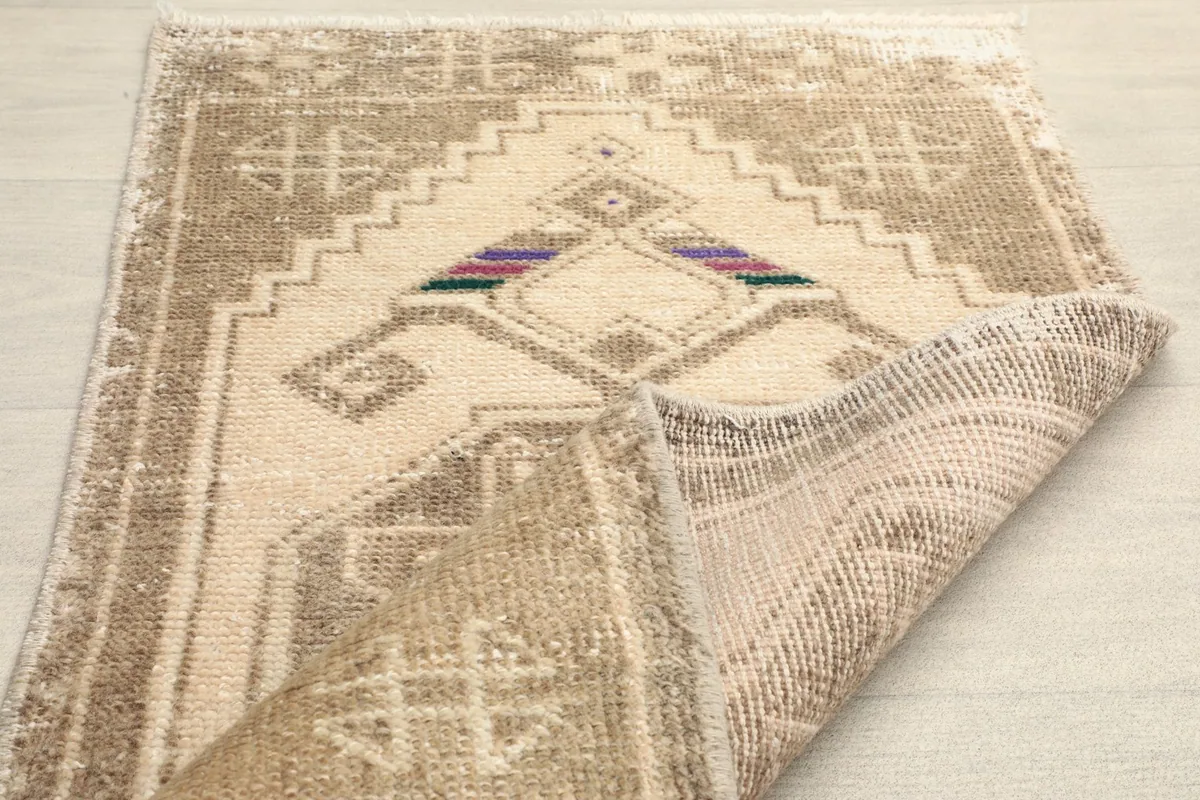 Angled view with a section of the rug folded back, displaying the tight hand-knotted construction.