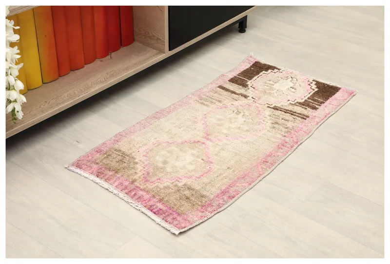 Full top view of the beige, pink, and brown vintage Anatolian doormat