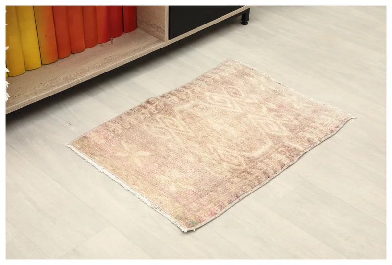 Full top view of the 1'9" x 2'5" vintage beige and pink geometric rug on a white background.