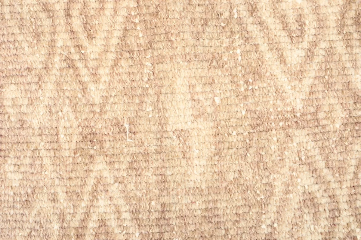 Close-up detail of the wool pile, showing the subtle geometric design and color variations.