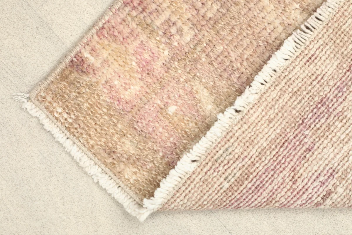 View of the rug's reverse side, showing the cotton foundation and the hand-knotted construction.