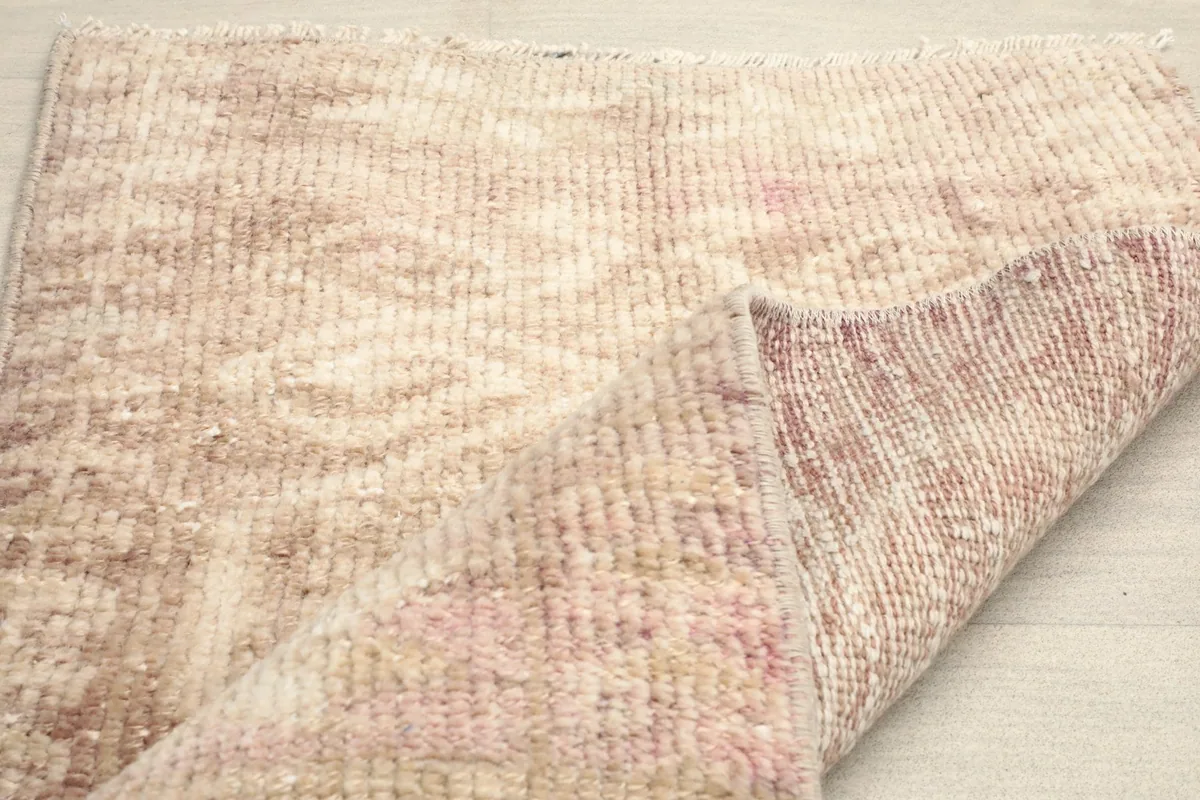 Partial fold of the rug, illustrating its flexibility and the uniform low pile.
