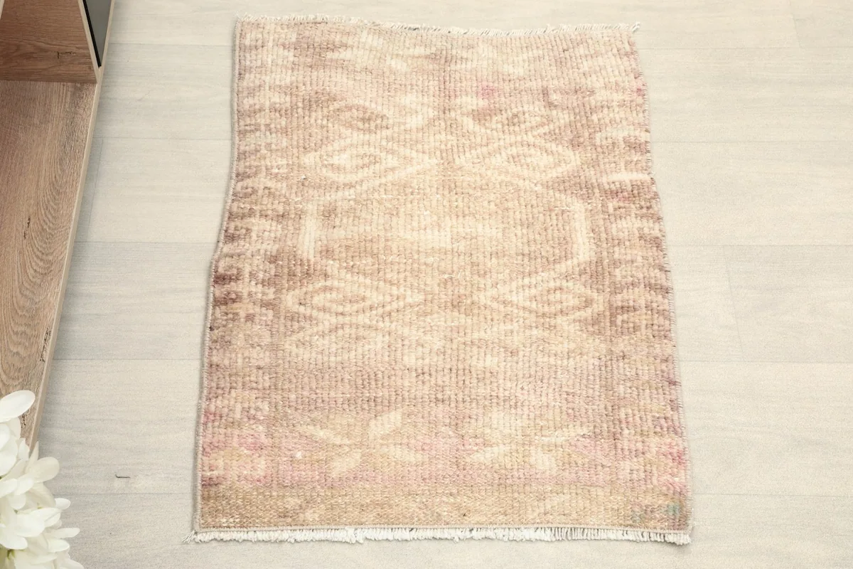 Overhead view of the hand-knotted vintage rug, showing its overall geometric pattern and muted colors.