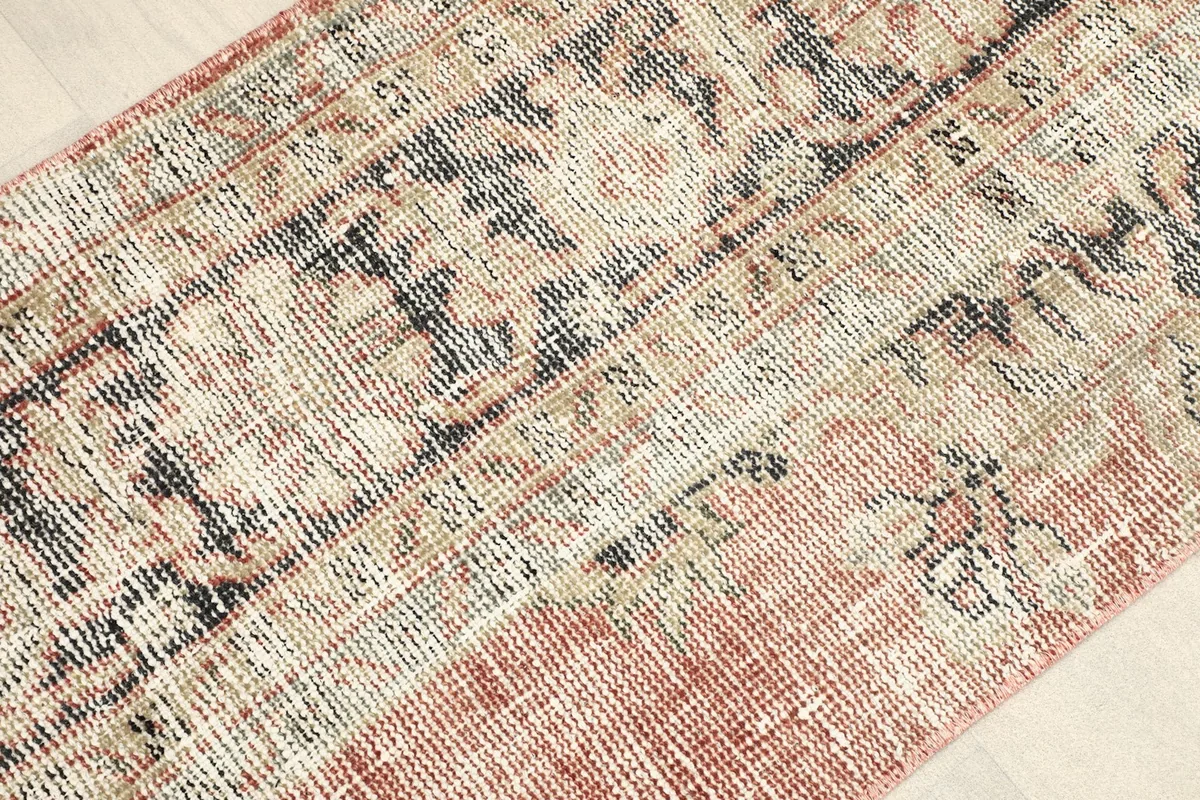 Angled view highlighting the distressed patina and low pile of the vintage doormat