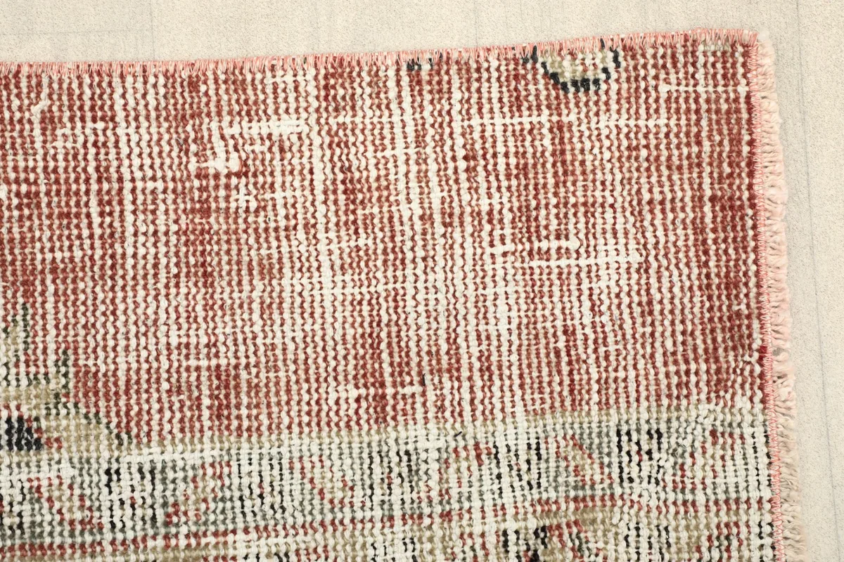 Close-up of the distressed rust section of the rug, revealing the wool texture