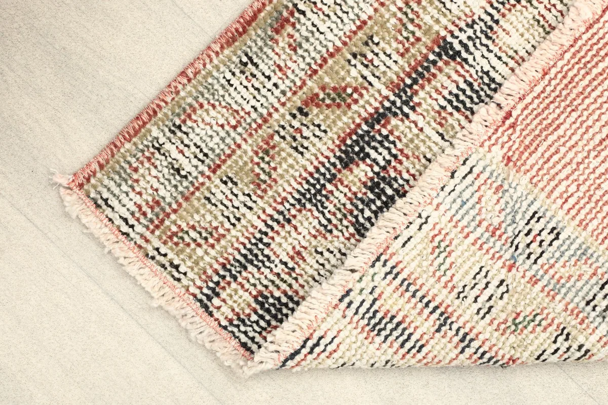 View of the back of the rug, showing the hand-knotted construction and cotton foundation