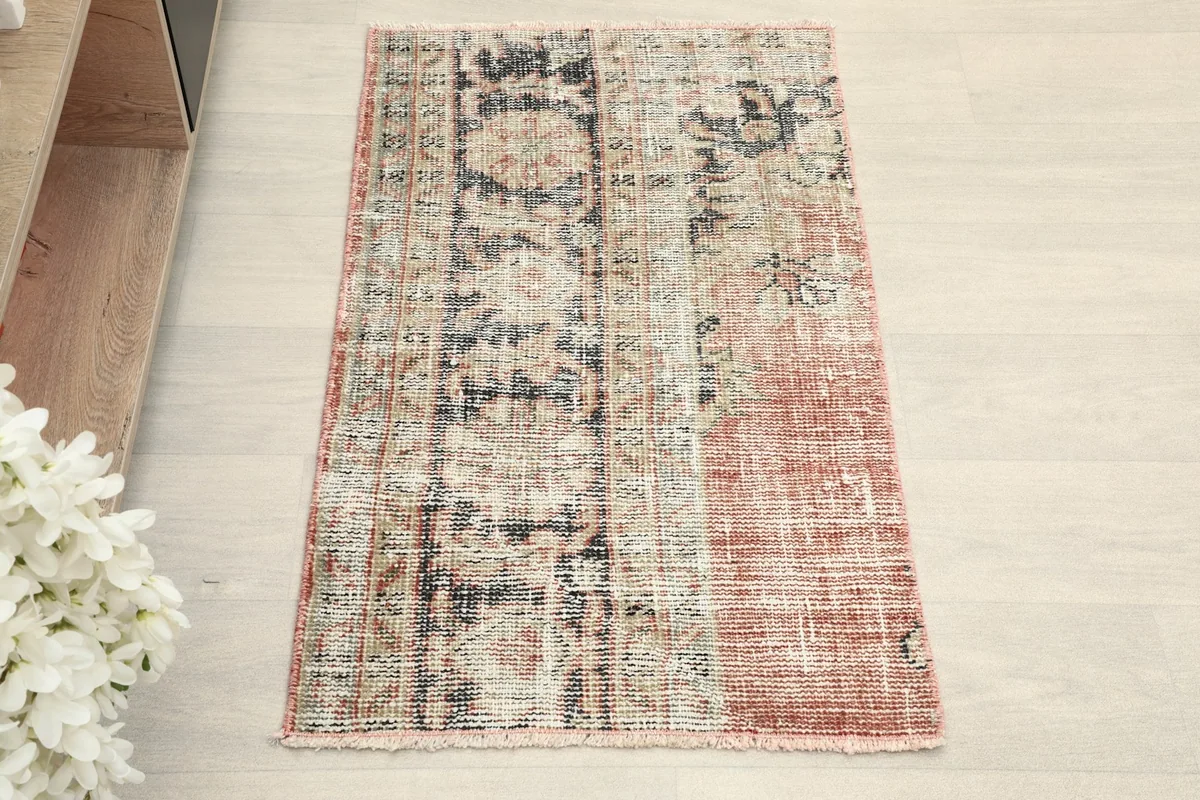 Overhead view of the hand-knotted wool rug, showing its faded floral and geometric patterns