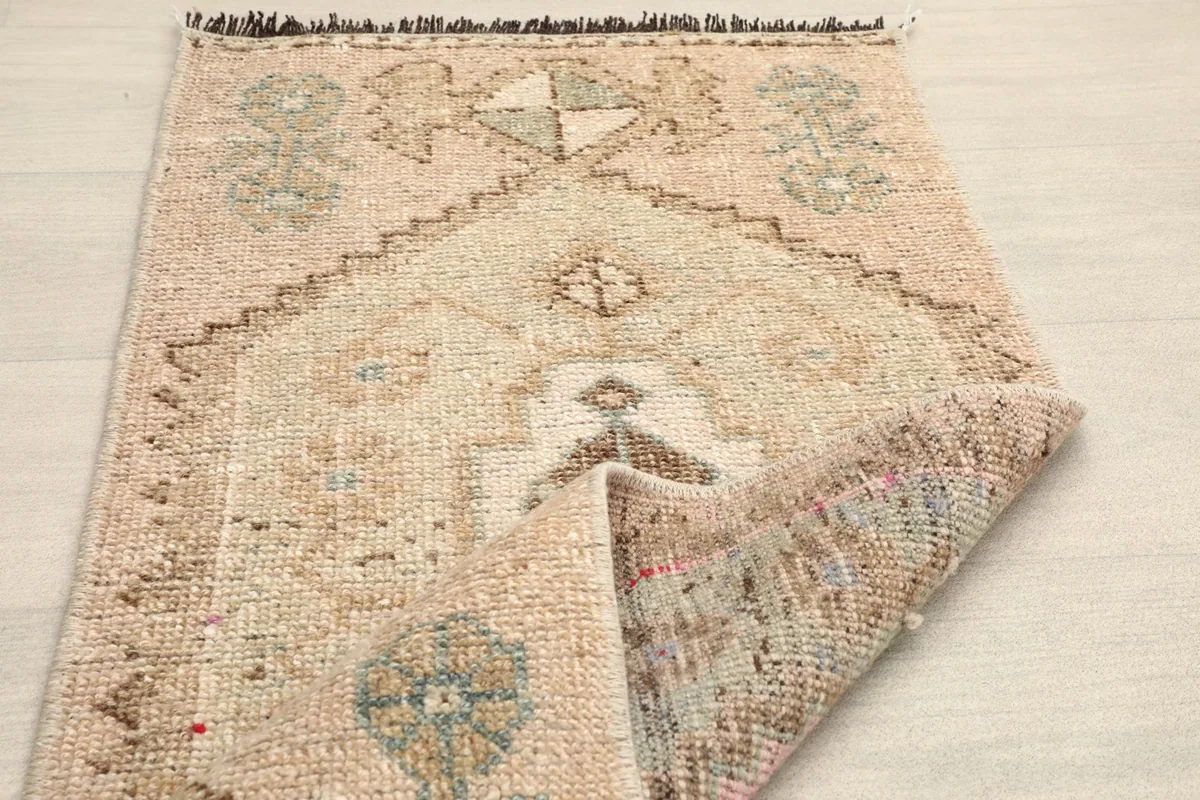 View of the doormat folded back, revealing the reverse side of the hand-knotted construction.